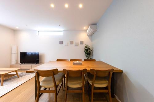 a dining room with a large wooden table and chairs at Amp flat HEC 02 in Muromimachi