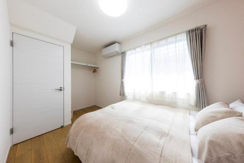 a bedroom with a large bed and a window at Amp flat HEC 02 in Muromimachi