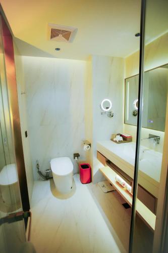 a bathroom with a toilet and a sink and a mirror at Ramada by Wyndham Vientiane Central in Vientiane
