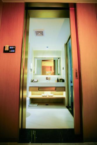 a bathroom with a sink and a mirror at Ramada by Wyndham Vientiane Central in Vientiane
