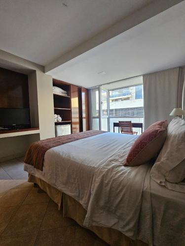 a bedroom with a large bed and a balcony at Departamento Caseros Centro in Salta