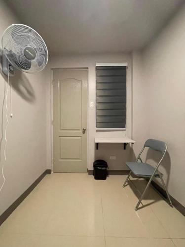 a room with a fan and a chair and a window at K and R Apartment Affordable Aircon Room with Wifi in Carcar