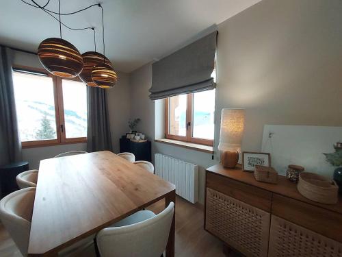 une salle à manger avec une table et des chaises en bois dans l'établissement Appartement neuf 4 personnes - Parking inclus - FR-1-356-534, à Valmorel