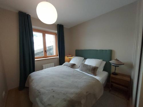 une chambre avec un grand lit et une fenêtre dans l'établissement Appartement neuf 4 personnes - Parking inclus - FR-1-356-534, à Valmorel