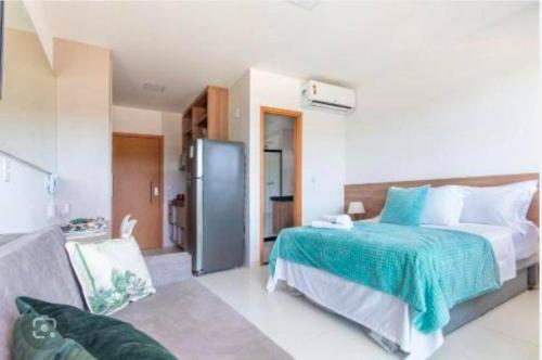 a bedroom with a large bed and a refrigerator at Loft Mana Experience INN in Ipojuca