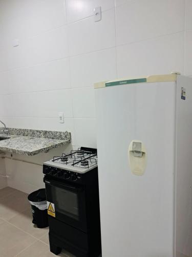 a kitchen with a black stove and a sink at Apartamento de 2 quartos - 900m da Praia! in Cabedelo