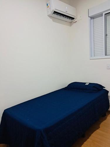 a bedroom with a blue bed in a room with a heater at Apartamento de 2 quartos - 900m da Praia! in Cabedelo