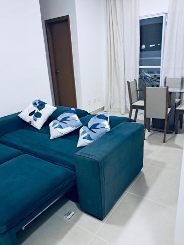 a blue couch with pillows on it in a living room at Apartamento de 2 quartos - 900m da Praia! in Cabedelo