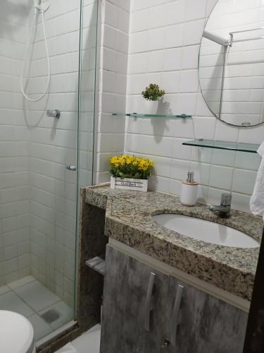 a bathroom with a sink and a shower at Flat Monte Castelo - Gravatá - Até 5 pessoas, próximo da área de lazer in Sairé