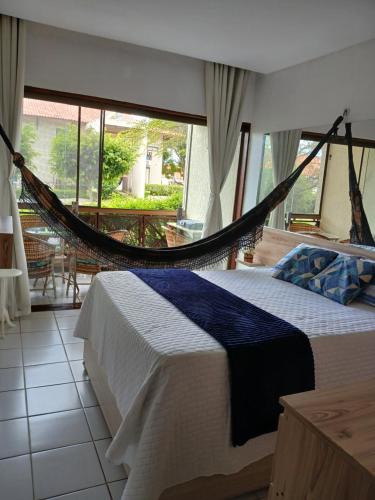 a hammock bed in a room with a balcony at Flat Monte Castelo - Gravatá - Até 5 pessoas, próximo da área de lazer in Sairé
