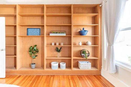 a book shelf with pots and plants in a room at Jennifer's Cozy Apt Walk to Brown In Unit Laundry in Providence
