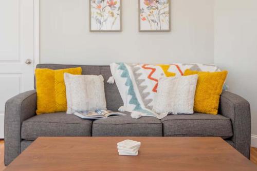 a living room with a couch with pillows and a table at Jennifer's Cozy Apt Walk to Brown In Unit Laundry in Providence