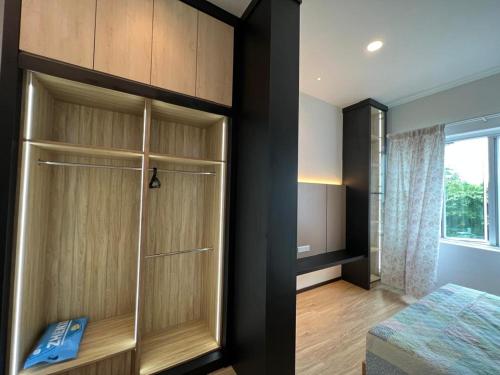 a bedroom with a closet with a bed and a window at Alan Garden Apartment in Sibu