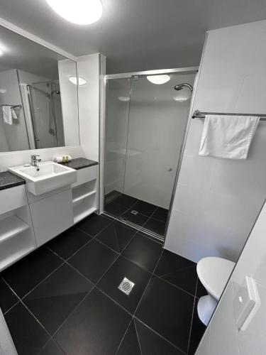 a bathroom with a shower and a sink at Aruba Beach Resort in Gold Coast