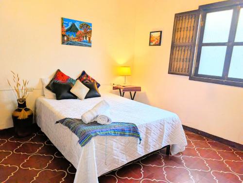 a bedroom with a bed with pillows on it at Casa Quetzalli, Los Nazarenos in Antigua Guatemala