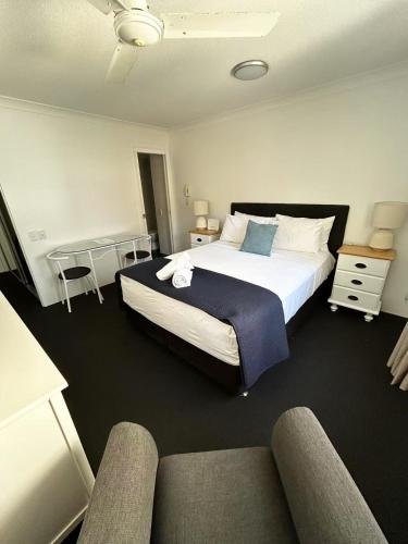 a bedroom with a large bed and a couch at Aruba Beach Resort in Gold Coast