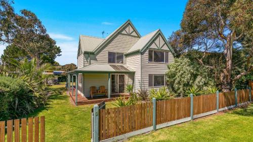 a house with a wooden fence in a yard at Woolamai Waters in Cape Woolamai