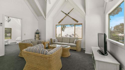 a living room with a couch and chairs and a tv at Woolamai Waters in Cape Woolamai