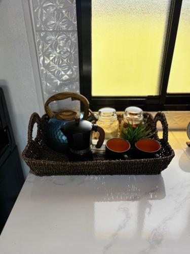 a basket with two cups and a tea pot on a table at Lovely tiny studio in Jarabacoa