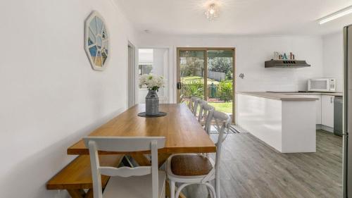 a kitchen and dining room with a wooden table and chairs at Woolamai Waters in Cape Woolamai