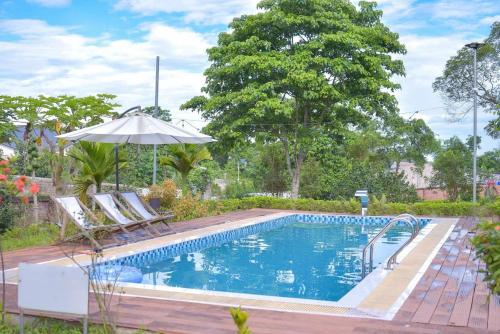 a swimming pool with two chairs and an umbrella at Kazin Villa in Xóm Gốc Gia