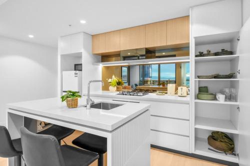 a kitchen with white cabinets and a white counter top at Queens Wharf - Brisbane CBD Luxury with pool and gym in Brisbane