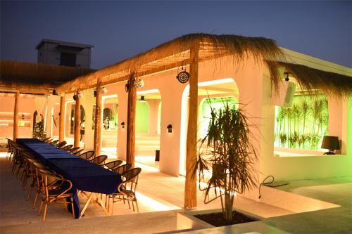 a long table and chairs on a patio at Shanheli wabi Sabi Natural Wind Hotel Chenghai Branch in Shantou