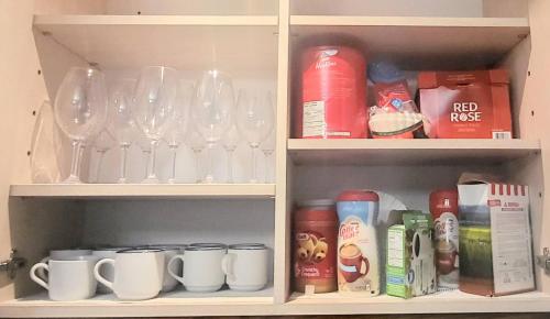 a cabinet filled with glasses and mugs and cups at Cozy Home Close to Attractions in Niagara Falls in Thorold