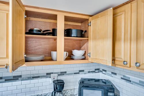 a kitchen with wooden cabinets with pots and pans at Quite and Spacious Apartment in Elizabeth