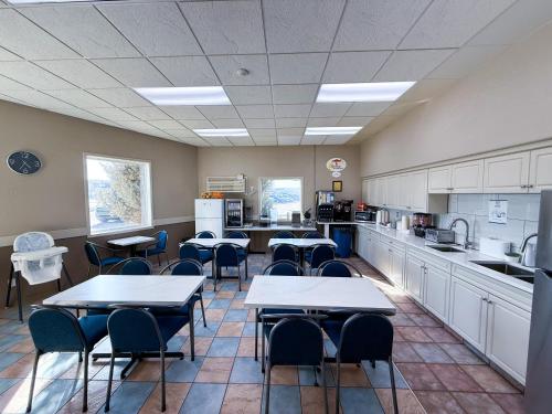 a classroom with tables and chairs and a kitchen at Super 8 by Wyndham Medicine Hat AB in Medicine Hat