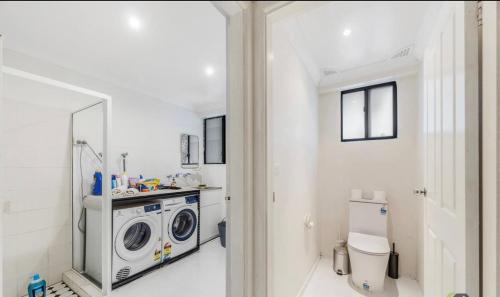 a bathroom with a washing machine and a toilet at 4BR Castle Hill Home Garage Near Mall & Park in Castle Hill