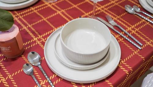 a table with a white bowl and plates and spoons at 4BR Castle Hill Home Garage Near Mall & Park in Castle Hill