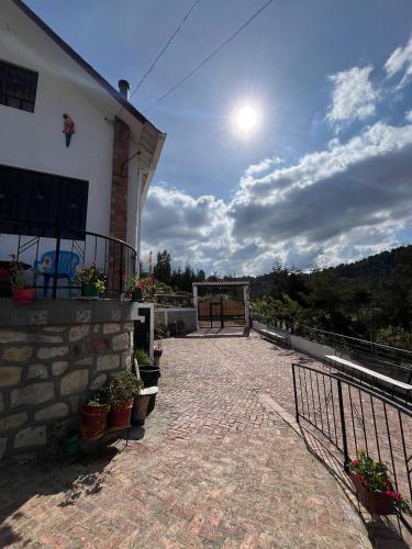 eine Terrasse eines Hauses mit der Sonne am Himmel in der Unterkunft Hospedaje Rural Yukaleña - Monguí in Monguí
