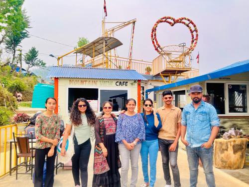 a group of people standing in front of a roller coaster at Mountain View cafe in Pokhara