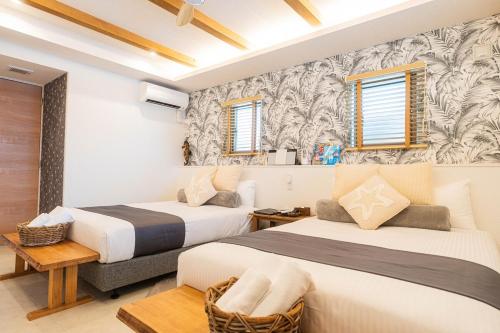 two beds in a room with two windows at ReVIERA Resort Villa in Chatan