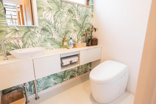 a bathroom with a white toilet and a sink at ReVIERA Resort Villa in Chatan