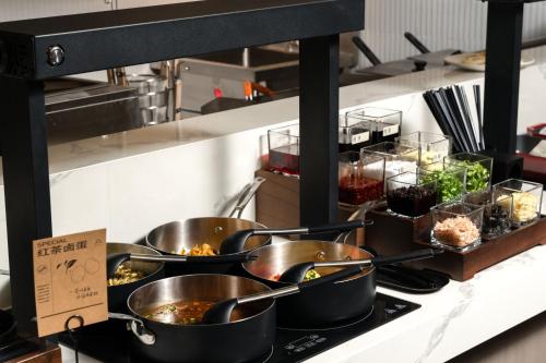 a group of pots and pans on a counter in a kitchen at Atour Hotel Hangzhou Cainiao Headquarter Fengxin Road in Hangzhou