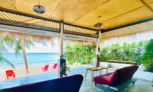 a living room with a view of the beach at The Scenery Beach Resort in Baan Khai