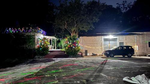 a car parked in front of a house with christmas lights at Woodside Homestay Wayanad in Batheri