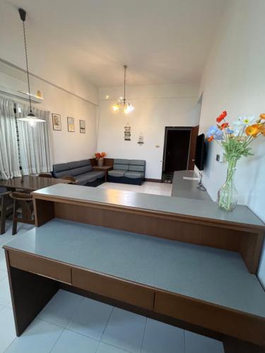 a living room with a vase of flowers on a table at Muang Thong Family Suite Hatyai in Hat Yai