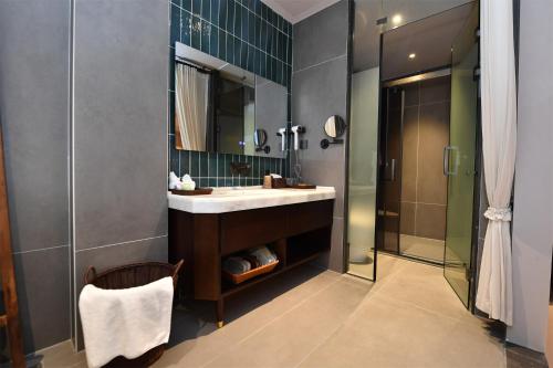 a bathroom with a sink and a shower at Shanheli wabi Sabi Natural Wind Hotel Chenghai Branch in Shantou