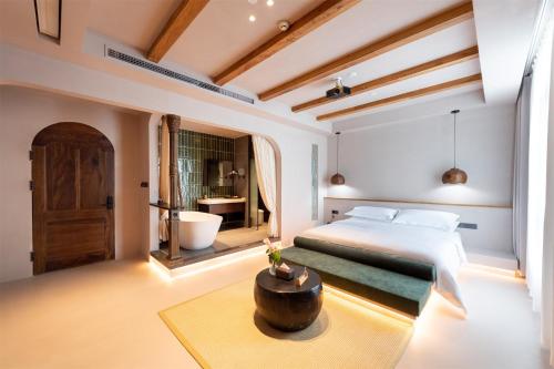 a bedroom with a large bed and a bathroom at Shanheli wabi Sabi Natural Wind Hotel Chenghai Branch in Shantou