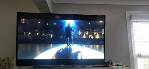 a television screen with a person standing on it at Cozy Home in Niagara-on-the-Lake in Niagara on the Lake