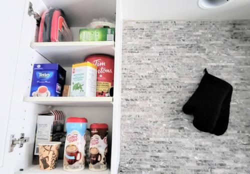 a kitchen pantry with books and food items on shelves at Cozy Home in Niagara-on-the-Lake in Niagara on the Lake