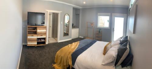 a bedroom with a bed and a tv on a dresser at Central, secure and upmarket Auckland in Auckland