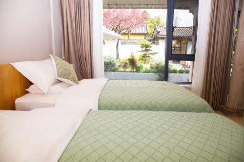 a bedroom with a bed and a window at Lijiang Jinghua Inn in Lijiang