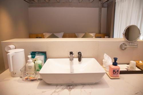 a white bathroom sink sitting on top of a counter at Lijiang Jinghua Inn in Lijiang