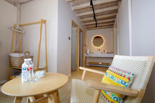 a living room with a table and a chair at Lijiang Jinghua Inn in Lijiang