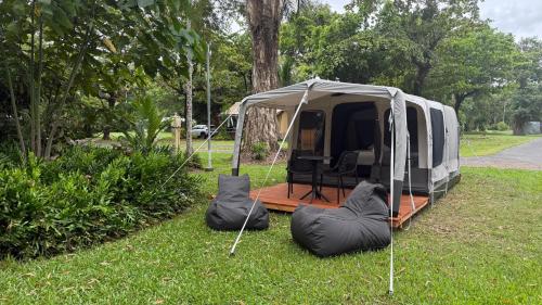 a white tent sitting in the grass in a field at Daintree Beach Resort in Wonga