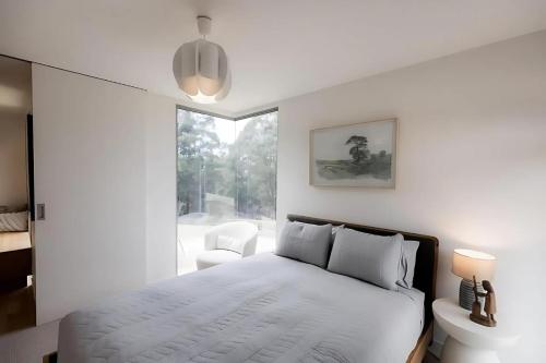 a white bedroom with a bed and a window at Woodbridge Hill Country Escape in Woodbridge